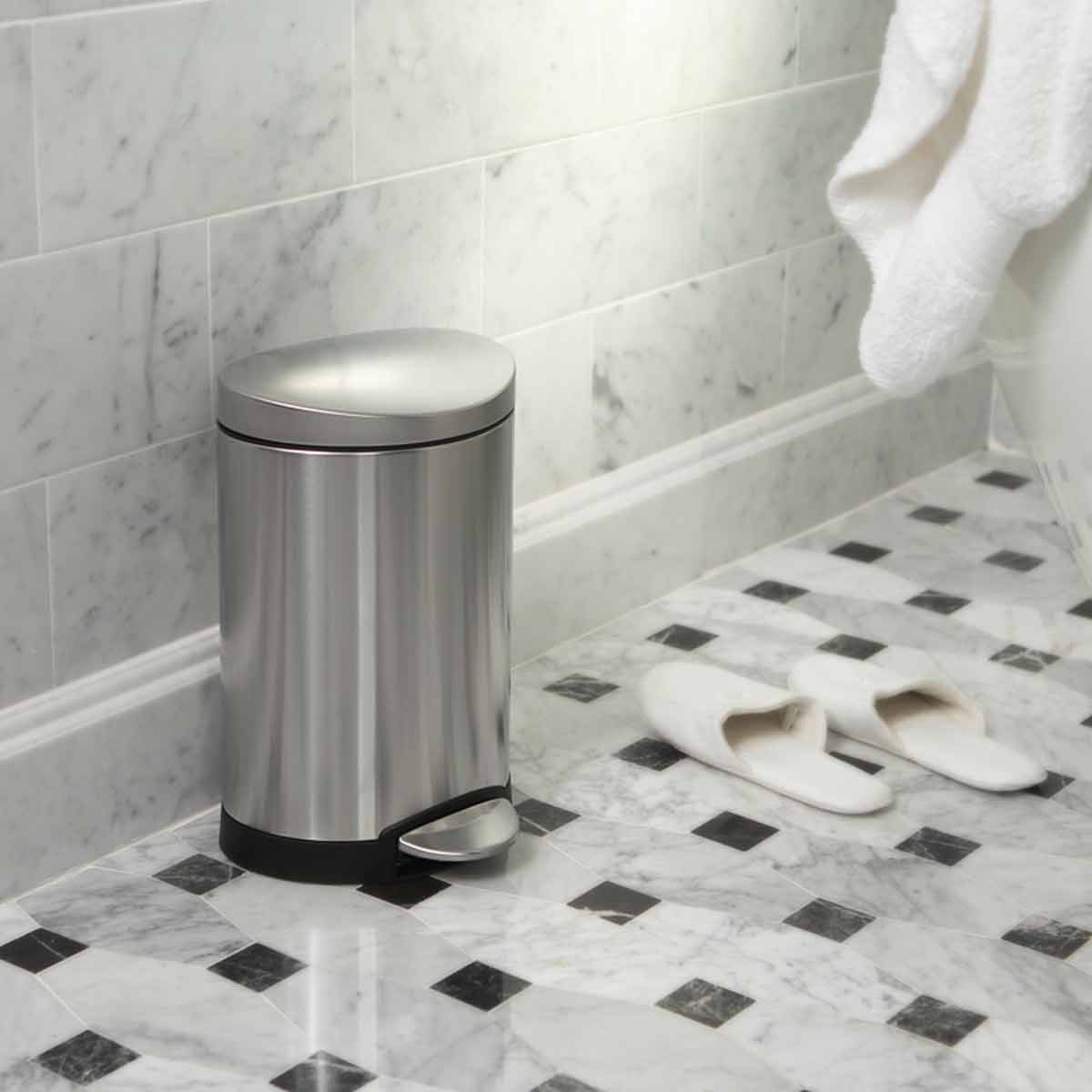 Simplehuman 6L Semi-Round Step Can in Brushed Stainless Steel used in a marble bathroom, space-saving hands-free pedal.