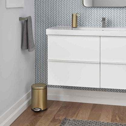 Lifestyle view of Simplehuman 4.5L Round Step Can in Brass finish, compact size for modern bathroom, hands-free pedal.