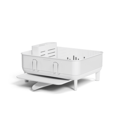Low-angle view of Simplehuman Compact Steel Frame Dishrack in White, showing adjustable drain spout and utensil caddy.