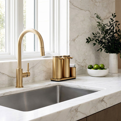Simplehuman's Dual 14 oz. Sensor Pump in Brass in a modern kitchen setting with marble counter top and wooden cabinets.